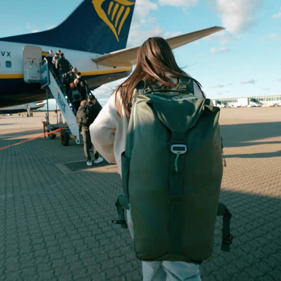Read article: A woman gets ready to board a plane wearing an Eagle Creek travel backpack